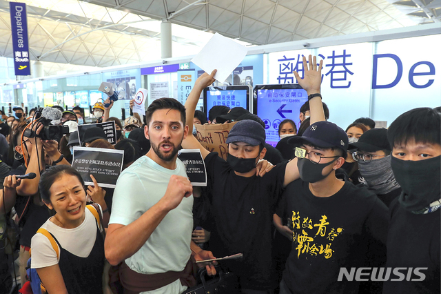 홍콩 국제공항에서 13일 저녁 공항 당국이 항공사의체크인 업무를 전면 중지시킨 후 출국장 점거 시위대는 수하물 카트로 출국 게이트로 가는 통로를 막아버렸다(출처: 뉴시스)