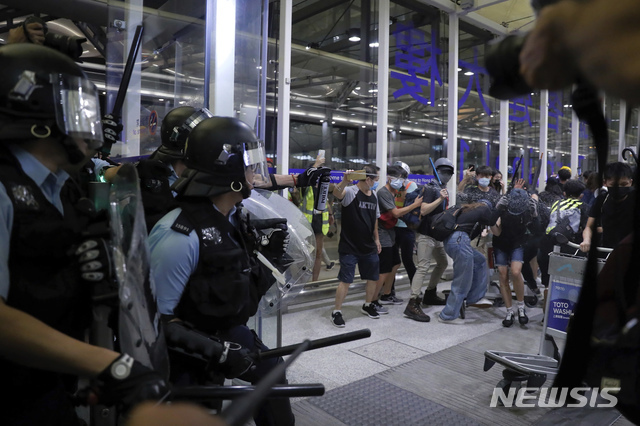 13일 밤 홍콩 국제공항에서 진압경찰이 시위대를 향해 최루액을 발사하며 해산을 시도하고 있다. 홍콩 국제공항은 시위대의 점거가 이어지면서 13일에도 극심한 혼란을 빚었다. (출처: 뉴시스)