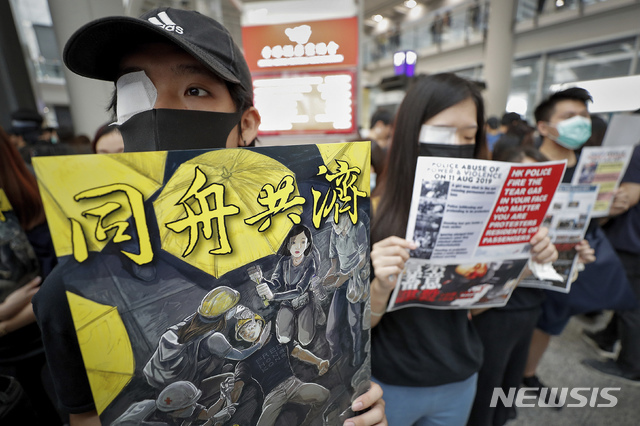12일(현지시간) 홍콩 국제공항 입국장에서 오른쪽 눈에 안대를 붙인 시위대가 시위를 벌이고 있다.지난 11일 홍콩 경찰이 고글을 착용한 한 여성 시위자에게 고무탄을 쏴 고글을 깨고 들어간 탄환이 여성을 실명시킨 것으로 전해진 바 있다. (출처: 뉴시스)