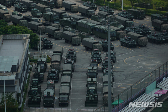 (중국 광둥성=AP/뉴시스) 홍콩과 인접한 중국 광둥성 선전의 스포츠 스타디움에서 16일(현지시간) 중국 인민해방군 소속 무장한 차량과 군용 트럭들이 늘어서 있다. 중국 정부와 매체들이 홍콩 시위를 ‘테러’와 ‘색깔 혁명’ 등으로 규정하고 홍콩 건너편 선전에 무장병력을 집결시키면서 홍콩 시위대에 대한 무력개입이 임박한 게 아니냐는 관측이 나오고 있다. 홍콩 시위대는 이번 주말 30만 명이 집결하는 시위를 계획하고 있어 중국의 무력개입 여부를 가르는 분수령이 될 것으로 전망되고 있다. 