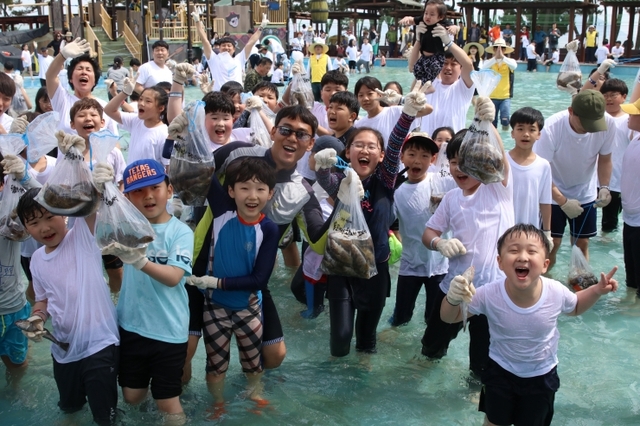 보성군 율포해변에서 활어잡기 페스티벌에 참여한 체험객들이 물고기를 잡고 자랑하고 있다. (제공:보성군) ⓒ천지일보 2019.8.19