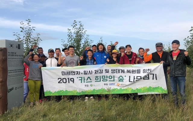 푸른아시아 관계자, 몽골 대학생, 현지 주민으로 구성된 환경봉사단 20여명이 몽골 ‘카스 희망의 숲’ 일대에서 나무심기 봉사활동을 마치고 기념촬영을 하고 있다. (제공: 오비맥주)
