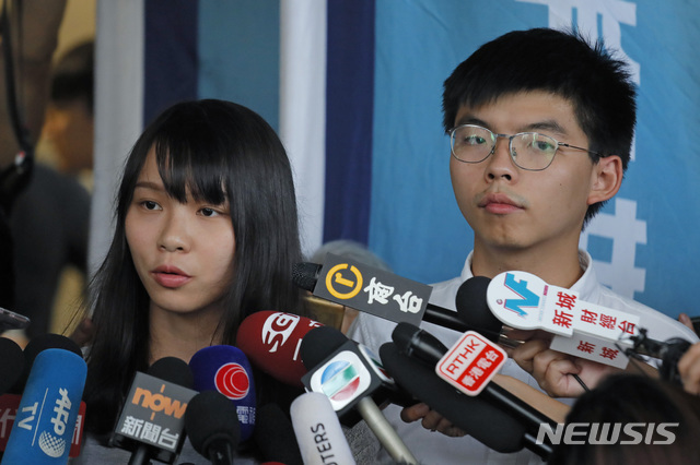 조슈아 웡(오른쪽) 홍콩 데모시스토당 비서장과 아그네스 초우가 30일(현지시간) 홍콩의 한 법원 밖에서 기자회견을 하고 있다. (출처: 뉴시스)