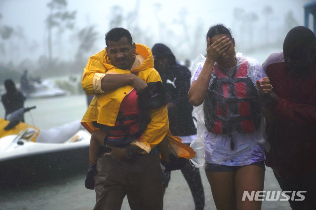 3일(현지시간) 허리케인 도리안이 바하마에 상륙해 비가 쏟아지는 가운데 한 가족이 구조돼 안전지대로 이동하고 있다. (출처: 뉴시스)