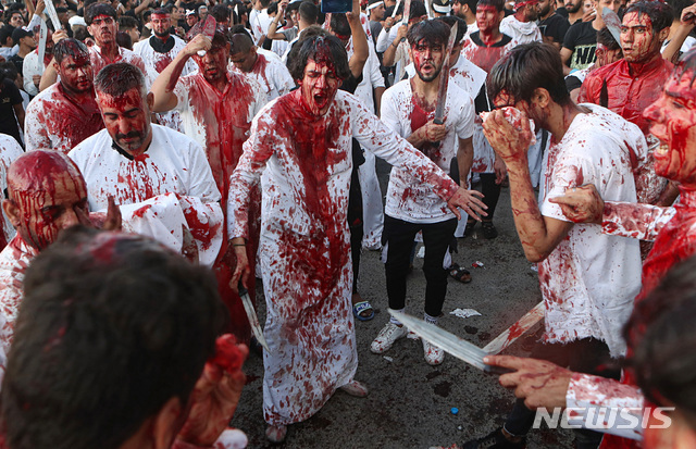 이라크 시아파 교도들이 10일(현지시간) 아슈라 기념일을 맞아 이라크 남동부 바스라에 모여 칼과 검으로 자신들의 몸을 자해하고 있다. (출처: AP/뉴시스)