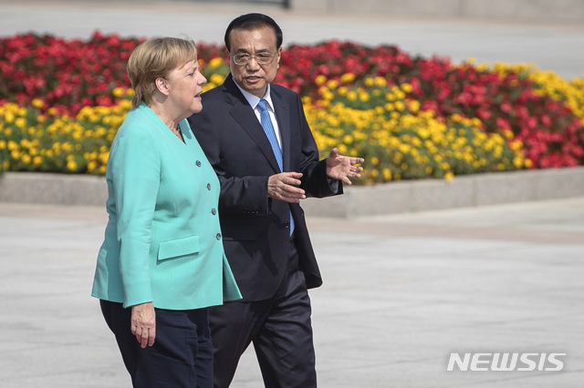 6일 중국을 방문한 앙겔라 메르켈 독일 총리(왼쪽)가 리커창 중국 총리(오른쪽)와 베이징 인민대회당에서 열린 환영식에 참석하기 위해 이동하고 있다(출처: 뉴시스)