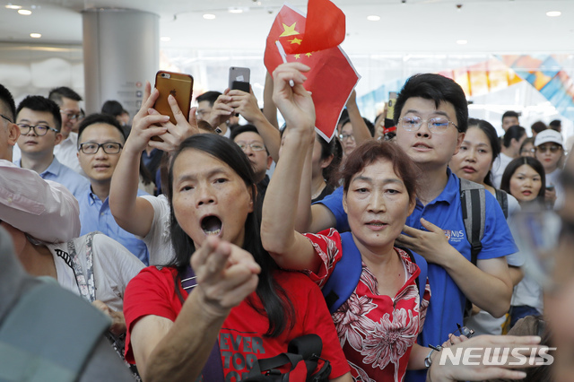 12일(현지시간) 홍콩 친중(親中) 지지자들이 홍콩 시내  국제금융센터(IFC) 쇼핑몰에서 중국 국기를 들고 홍콩 민주화 시위대와 언쟁을 벌이고 있다. (출처: 뉴시스)