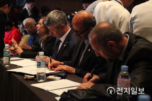 ㈔하늘문화세계평화광복(HWPL, 대표 이만희)이 2014년 9월 18일 서울 63빌딩컨벤션센터 그랜드볼룸에서 세계평화를 위한 종교대통합 협약식을 치렀다. 이날 협약식에 참석한 인사들이 종교대통합 평화협약서에 서명하고 있다. ⓒ천지일보