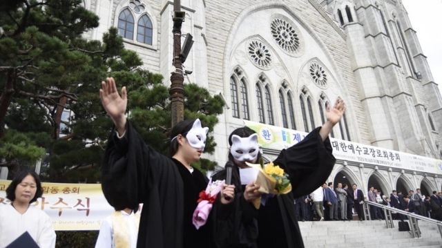 기독교반성폭력센터가 예장합동 정기총회가 열린 23일 서울 충현교회 앞에서 여성 안수 퍼포먼스를 마무리한 뒤 축도하고 있다. (출처: 기독교반성폭력센터)