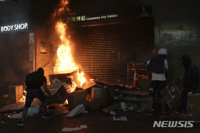 4일 저녁 홍콩 지하철 코즈웨이 베이역 입구에서 한 시위대들이 불을 지르고 있다. (출처: 뉴시스)