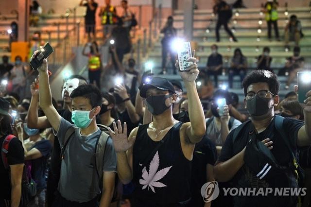 5일 홍콩 삼수이포에서 마스크를 쓴 사람들이 플래시몹에서 스마트폰을 밝히고 있다. (출처: 연합뉴스)