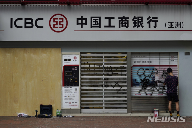 7일(현지시간) 홍콩의 한 중국계 은행의 직원이 홍콩 민주화 시위대의 낙서로 훼손된 벽을 청소하고 있다. (출처: 뉴시스)