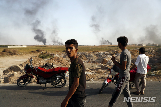 10일(현지시간) 터키-시리아 국경지대의 악카칼레 지역 주민들이 터키군 폭격으로 시리아 지역에서 연기가 피어오르는 모습을 지켜보고 있다. (출처: 뉴시스)