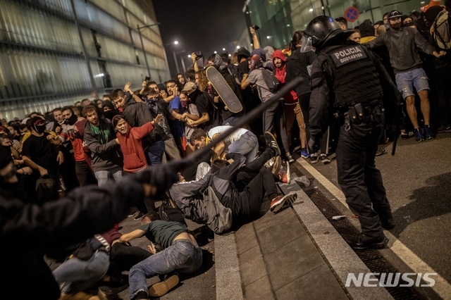14일(현지시간) 스페인 바르셀로나의 엘프라트 공항 밖에서 시위대와 경찰이 충돌하고 있다(출처: 뉴시스)