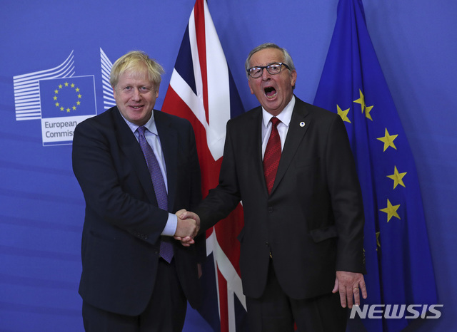 보리스 존슨 영국 총리(왼쪽)와 장 클로드 융커 유럽연합(EU)집행위원장이 17일(현지시간) 벨기에 브뤼셀 EU 본부에서 만나 악수하고 있다. 이날 양측은 브렉시트안에 합의했다고 밝혔다. (출처: 뉴시스)