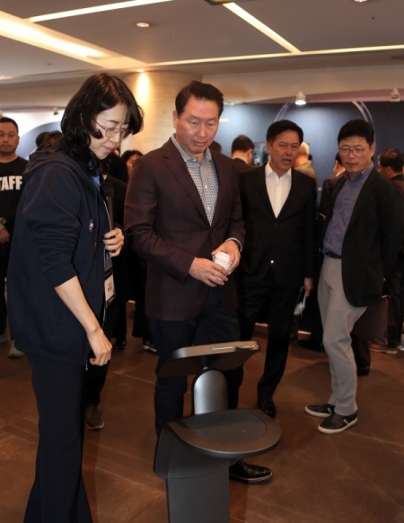 최태원 SK 회장이 28일 서울 워커힐호텔에서 열린 ‘SK ICT 테크 서밋 2019’에 참석해 SK텔레콤 인공지능 서비스 '누구'를 탑재한 퍼스널 로봇에 대한 설명을 듣고 있다. (제공: SK텔레콤)