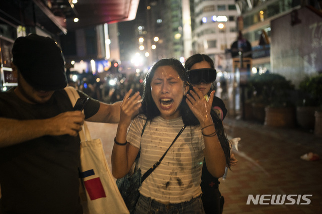 홍콩 경찰의 집회 금지 조치에도 거리로 몰려나온 시위대가 경찰과 충돌한 가운데 한 여성이 최루탄에 괴로워하고 있다. (출처: 뉴시스)