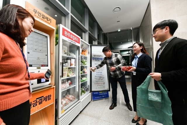 한국전기안전공사 직원들이 본사 로비에 설치된 완주로컬푸드 무인판매대를 이용해 지역 농산물을 구매하고 있다. (제공: 한국전기안전공사) ⓒ천지일보 2019.11.12