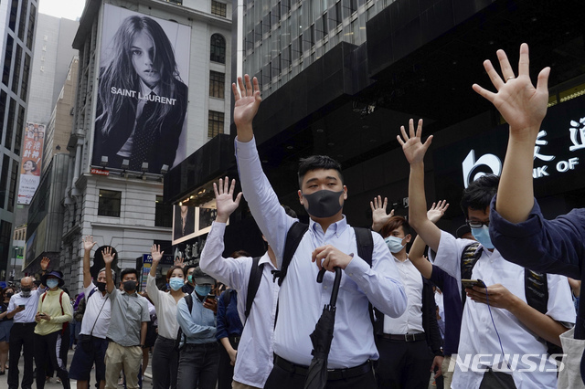 홍콩 금융가에서 12일 점심시간에 사무실 근로자들, 일명 '넥타이부대'가 시위대가 정부에 요구하는 5가지를 상징하는 다섯 손가락을 펼쳐보이며 동조 시위를 벌이고 있다(출처: 뉴시스)