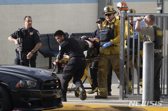 14일(현지시간) 미 캘리포니아주 샌타클래리타의 서거스 고교에서 총격 사건이 발생한 후 구급대원이 부상자를 급히 옮기고 있다. 경찰은 총격으로 최소 2명이 숨지고 3명이 부상했으며 용의자가 스스로에게 총을 쏴 부상, 체포된 뒤 병원으로 옮겨졌다고 밝혔다(출처: 뉴시스)