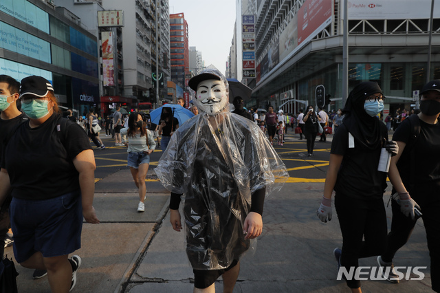 가면과 마스크로 얼굴을 가린 홍콩 시민들이 지난 12일 시내 중심가에서 행진하고 있다. (출처: 뉴시스)