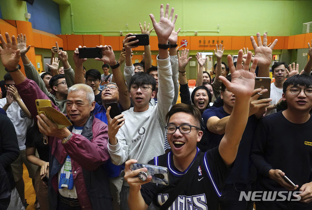 25일(현지시간) 홍콩 범민주진영 앵거스 웡 지지자들이 전날 치러진 구의원 선거 개표 결과 승리가 확정되면서 환호하고 있다. (출처: 뉴시스)