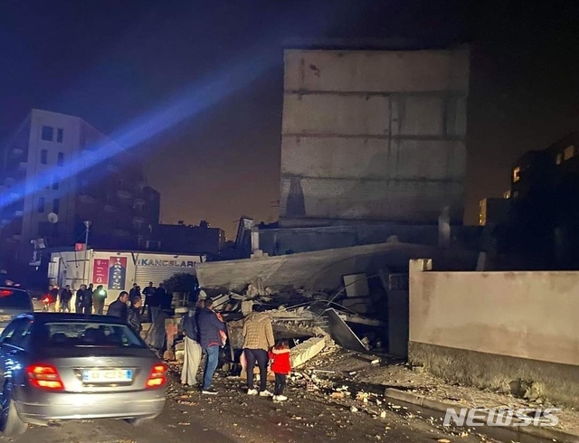 알바니아 수도 티라나에서 서쪽으로 33㎞ 떨어진 두레스에서 26일 새벽 발생한 규모 6.4의 강진으로 무너진 건물을 대피한 주민들이 바라보고 있다(출처: 뉴시스)