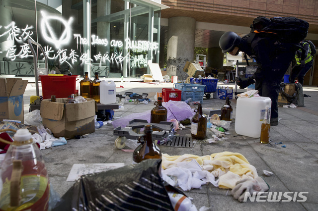 홍콩 경찰들이 28일 시위대가 점거했던 이공대 안으로 들어가 상황을 점검했다. 이날 잔류 시위대를 체포하지는 않았다. 사진은 한 경찰이 버려진 물건들을 살펴보고 있는 모습(출처: 뉴시스)