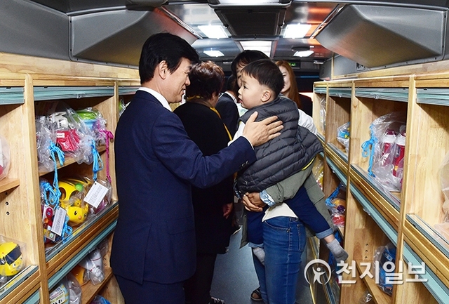 지난달 7일 진주실내체육관에서 이동식 장난감 은행 ‘해피버스데이’ 개소식이 열린 가운데 조규일 시장이 버스 안에서 아이와 인사를 나누고 있다. (제공: 진주시) ⓒ천지일보 2019.12.4