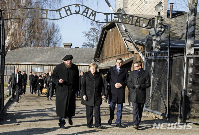 6일 폴란드 소재 나치 강제수용소 아우슈비츠-비르케나우 단지를 처음으로 찾은 독일의 앙겔라 메르켈 총리가 마테우시 모라비에츠키 총리(오른쪽두번째)와 함께 '노동은 너희들을 자유롭게 한다'라는 문구가 명기된 정문을 지나고 있다(출처: 뉴시스)