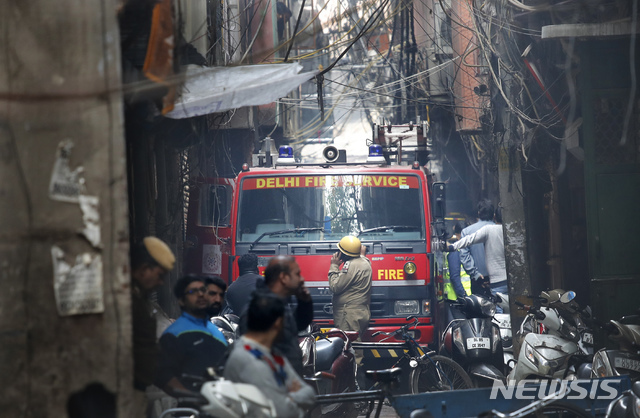 [뉴델리=AP/뉴시스] 8일(현지시간) 인도 뉴델리의 아나즈만디 지역 6층짜리 공장에서 불이 나 현장 인근 골목에서 소방차가 대응하고 있다. 경찰은 이 화재로 최소 43명이 숨지고 50여 명이 부상했다고 밝혔다. 2019.12.08.