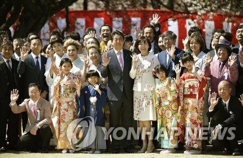 아베 신조 총리 부부가 2019년 4월 13일 도쿄 ‘신주쿠 교엔’에서 열린 ‘벚꽃을 보는 모임’ 행사에서 기념사진 촬영에 응하고 있다. (출처: 연합뉴스)