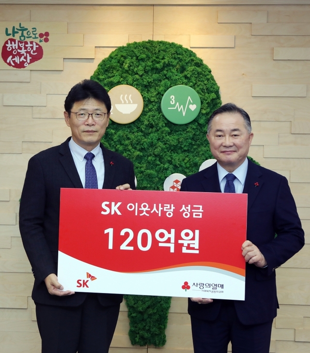 이형희 SK SV위원장(왼쪽)이 19일 서울 중구 사랑의 열매 회관에서 예종석 사회복지공동모금회장에게 이웃사랑 성금을 전달하고 있다. (제공: SK)