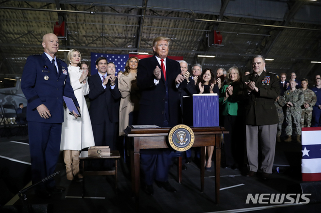 도널드 트럼프 미국 대통령이 20일(현지시간) 워싱턴DC 인근 앤드루스 공군기지에서 2020년도 국방수권법(NDAA)에 서명 후 참가자들과 이를 자축하고 있다. (출처: 뉴시스)