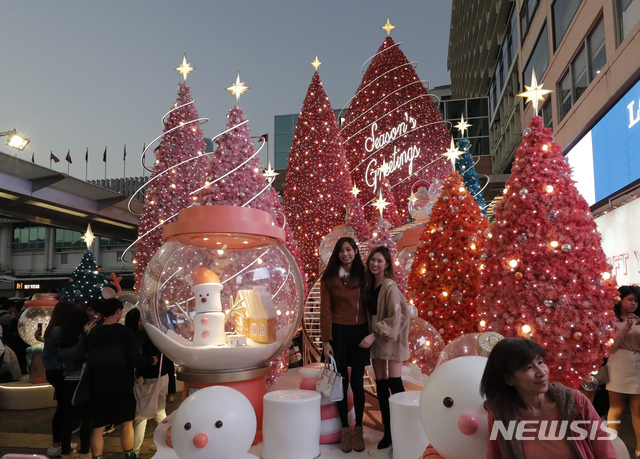 [홍콩=AP/뉴시스] 24일 홍콩의 하버 시티 쇼핑몰에서 고객들이 크리스마스 트리 장식에서 사진 찍기 위해 포즈를 취하고 있다. 2019. 12. 24.
