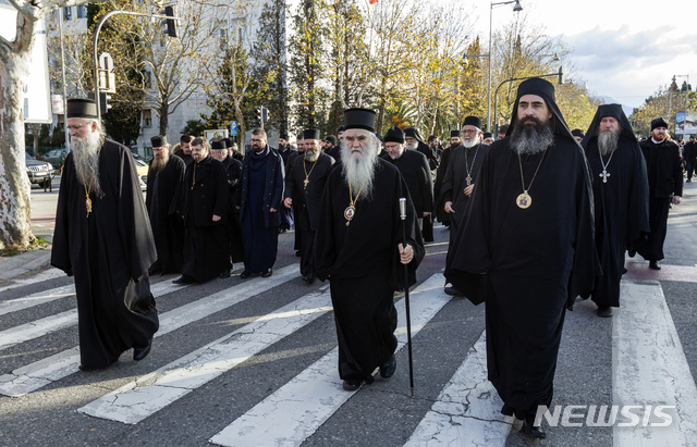 [포드고리차(몬테네그로)= AP/뉴시스] 몬테네그로 포드고리차에서 12월 24일(현지시간)교회재산등록법에 반대하는 세르비아정교회 사제들이 행진하고 있다. 2020.01.02