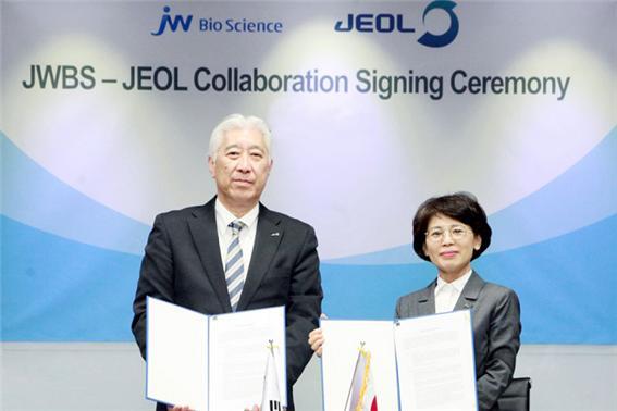 함은경 JW바이오사이언스 대표(오른쪽)와 사이토 신 제올 의료기기사업운영 총책임자가 계약서에 서명한 뒤 기념촬영을 하고 있다. (제공: JW홀딩스) ⓒ천지일보 2020.1.13