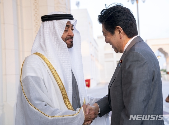 아랍에미리트(UAE)를 방문한 아베 신조 일본 총리(오른쪽)가 13일(현지시간) 셰이크 무함마드 빈 자예드 알 나흐얀 아부다비 UAE 왕세제 겸 통합군 부총사령관과 악수하고 있다. (출처: 뉴시스)