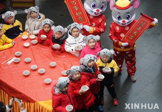 2일(현지시간) 중국 장쑤성 난징의 슈엔장쓰에서 라바 축제가 열려 어린이들이 새해의 상징인 쥐 캐릭터들과 '라바 죽'을 먹고 있다(출처: 뉴시스)