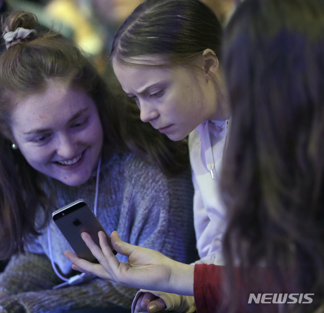 스웨덴 십대 환경운동가 그레타 툰베리가 21일(현지시간) 스위스 다보스에서 열린 세계경제포럼에 참석해 스마트폰을 들여다 보고 있다(출처: 뉴시스)