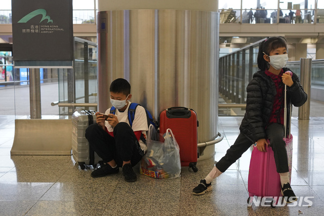 '우한발 폐렴' 공포가 확산되는 가운데 25일 홍콩 공항에서 두 어린이가 마스크가 쓰고 항공기 탑승을 기다리고 있다(출처: 뉴시스)