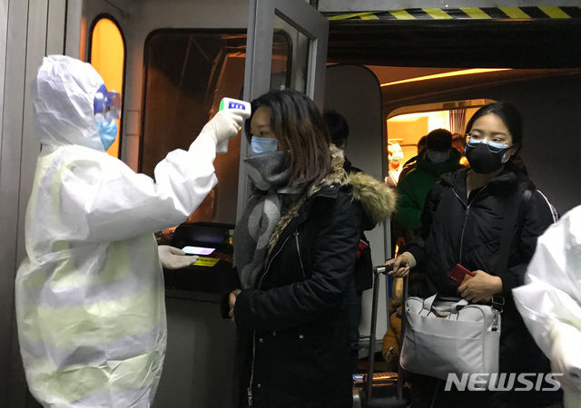보호복을 입은 보건 관계자들이 22일 중국 베이징 공항에서 우한시에서 도착한 승객들의 체온을 체크하고 있다. 중국은 신종 코로나바이러스로 발생하는 우한 폐렴의 확산을 막기 위해 23일부터 모든 항공기와 열차들의 우한 출발을 막기 시작했다. (출처: 뉴시스)
