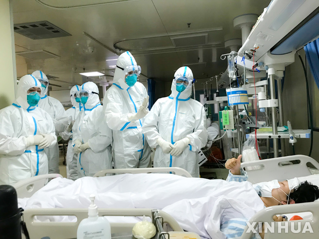 중국 베이징의 병원에서 27일 신종 코로나 바이러스에 감염된 환자가 자신을 치료해준 의료진을 향해 엄지손가락을 들어 올려 보이고 있다. (출처: 뉴시스)