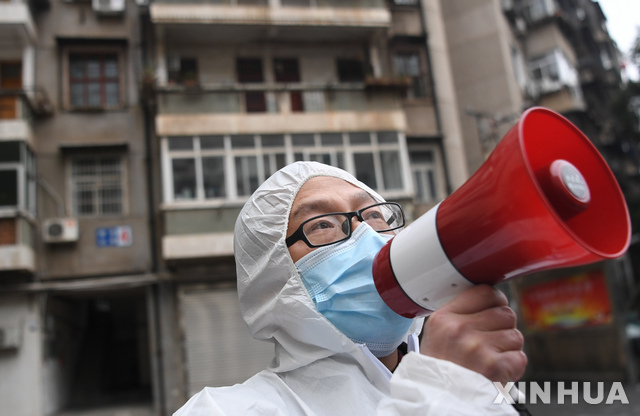 12일 중국 후베이성 우한시 차이뎬구에서 한 지역 활동가가 거주자들에게 코로나19 관련 건강 체크사항을 알리고 있다. (출처: 뉴시스)