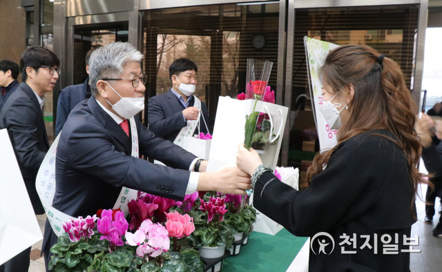 이대협 농협 서울지역본부장(왼쪽)이 14일 아침 서울지역본부 로비에서 출근하는 직원에게 꽃 나눔 행사를 실시한 가운데 꽃을 나눠주고 있다. (제공: 농협) ⓒ천지일보 2020.2.17