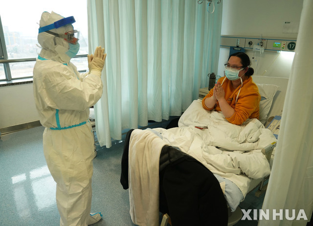 18일(현지시간) 중국 후베이성 우한의 한 병원에서 신종 코로나바이러스 감염증(코로나19) 치료를 받는 한 여성이 주치의에게 고마움의 인사를 하고 있다(출처: 뉴시스)