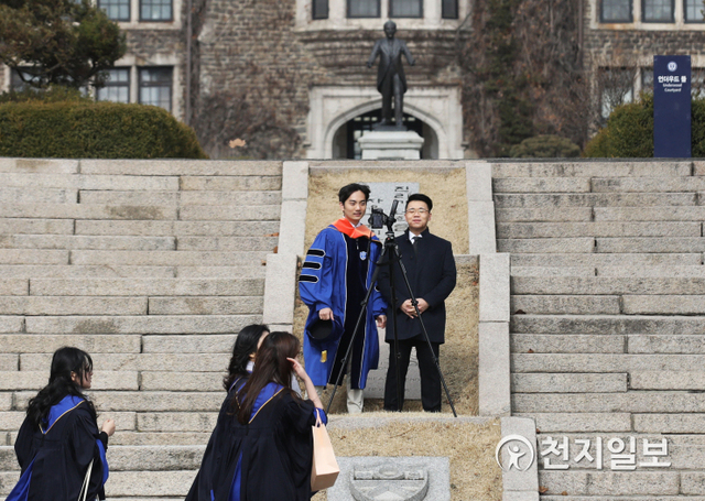 내 사진은 내가 [천지일보=남승우 기자] 22일 오후 서울 서대문구 연세대학교에서 한 졸업생이 휴대폰 카메라와 삼각대를 이용해 셀프 졸업사진을 찍고 있다. ⓒ천지일보 2020.2.22
