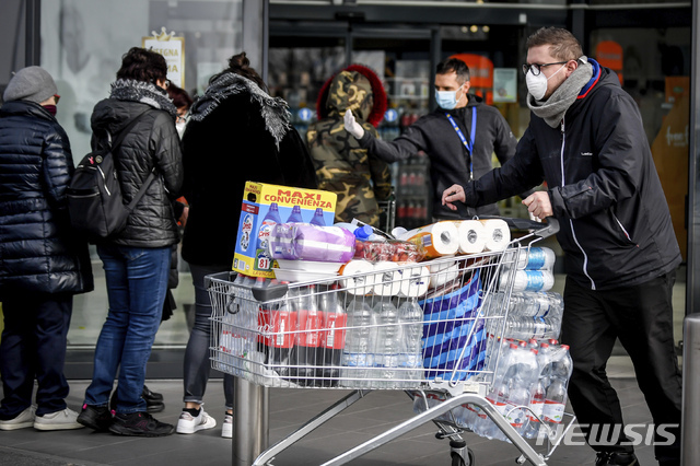 23일 북부 이탈리아 도시의 한 슈퍼마킷 앞에서 마스크 쓴 시민들이 줄을 서 기다리고 있다. (출처: 뉴시스)