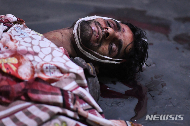 25일(현지시간) 인도 뉴델리에서 시민권법 찬반 시위 중 힌두교 성향 지지자와 무슬림 및 대학생 반대파 간의 충돌로 부상한 한 남성이 피를 흘리며 누워 있다(출처: 뉴시스)