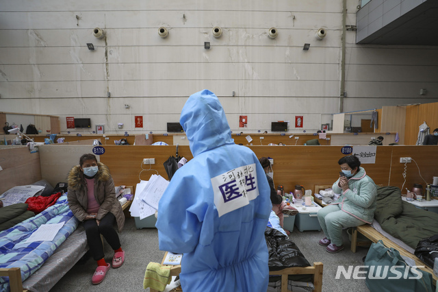 지난달 21일(현지시간) 중국 후베이성 우한의 타즈후 체육센터에 마련된 임시 병원에서 한 의료 종사자가 신종 코로나바이러스 감염증(코로나19) 환자들을 진료하고 있다. (출처: 뉴시스)